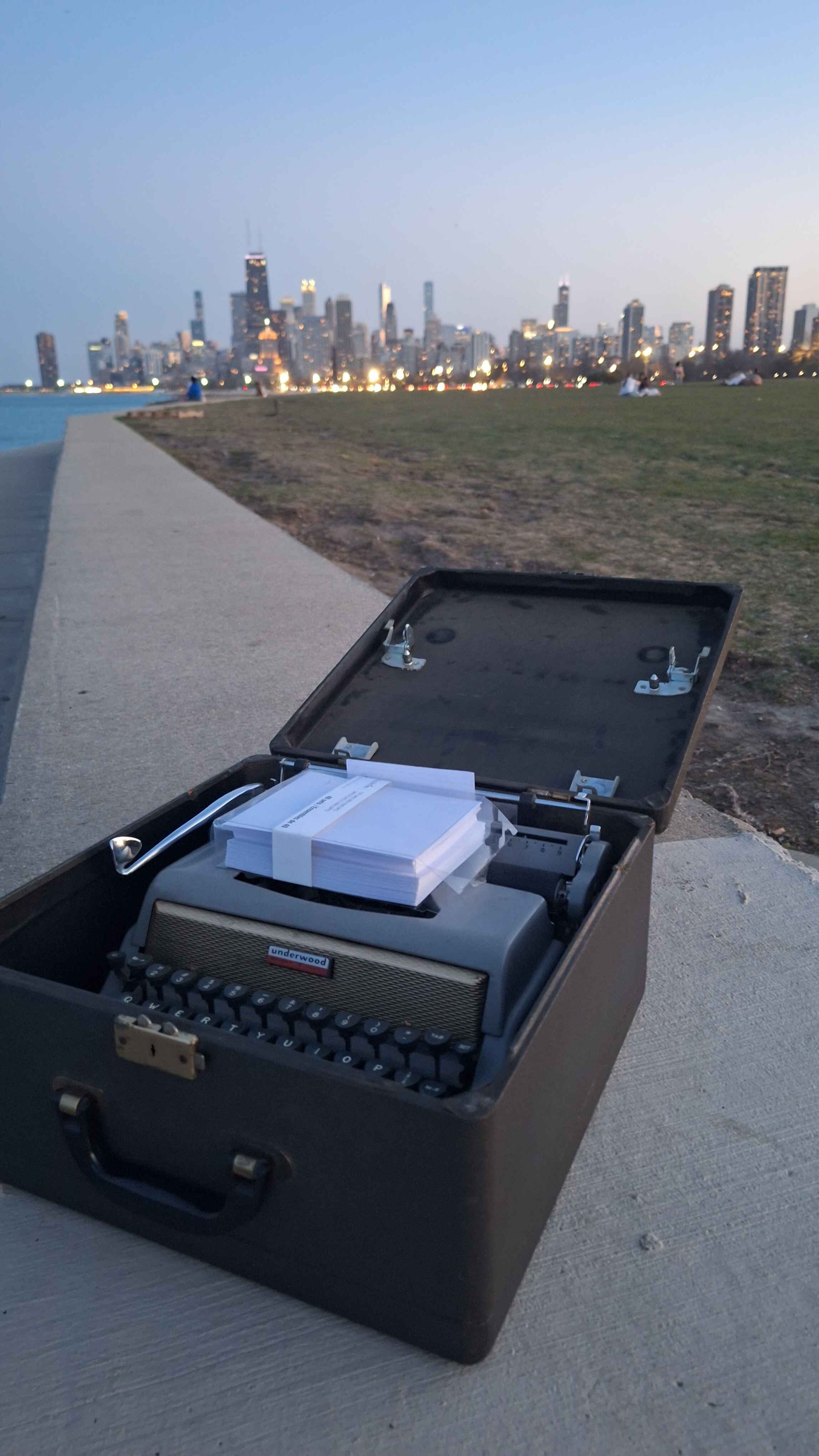 a typewriter in a box in front of the chicago skyline